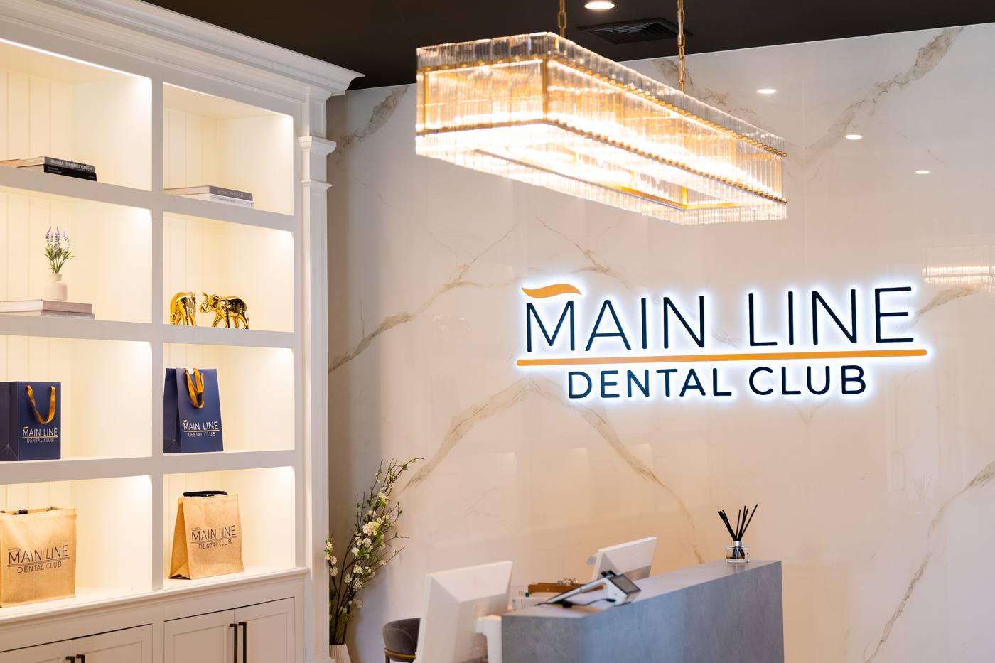 The marble reception and illuminated Main Line Dental Club sign